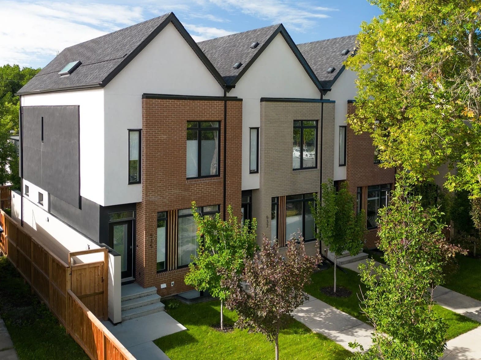 Modern brick 6-plex townhome building on a sunny residential street