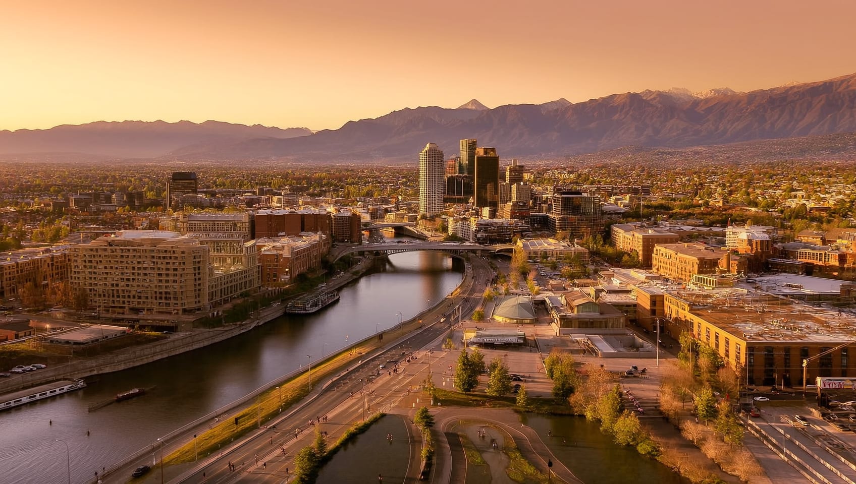 Aerial view of downtown Calgary at sunset with the Rocky Mountains and Bow River